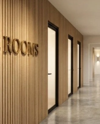 White-oak slat wall and patina-brass signage in the corridor at the Community Church Edition