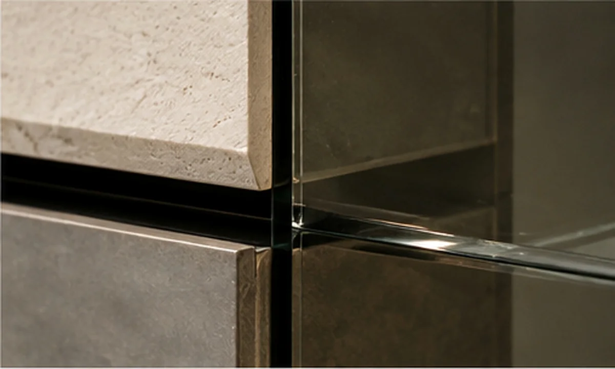 Travertine, blackened metal and glass meeting at a junction